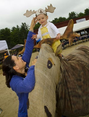 Lucy McCarthy, 19 months, was all excited as her mother Jill placed antlers on her head while sitting high upon moose replica during the Woods, Water & Wildlife Festival which took place on Saturday, at Branch Hill Farm in Milton Mills. Photo by Daryl Carlson/Fosters.com