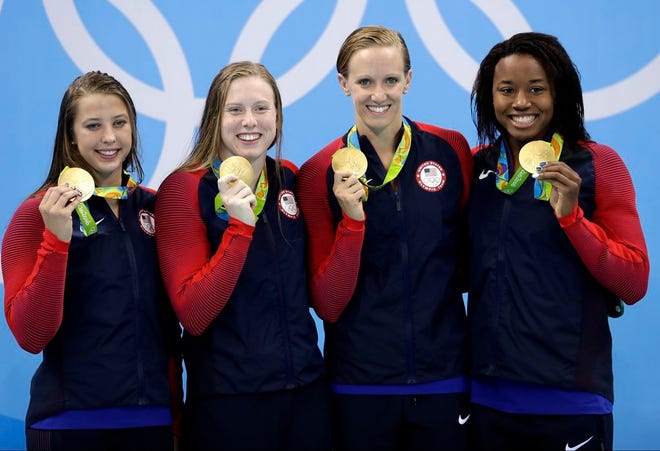 From left to right, United States' Kathleen Baker, Lilly King, Dana Vollmer and Simone Manuel display their gold medals for the women's 4 x 100-meter medley relay final during the swimming competitions at the 2016 Summer Olympics, Saturday, Aug. 13, 2016, in Rio de Janeiro, Brazil. (AP Photo/Michael Sohn)