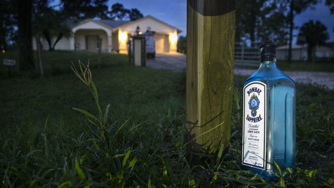 A bottle of gin sits at the base of the mailbox Friday morning June 10, 2016 outside the home where a 17-year-old was shot and killed late Thursday night at a graduation party. (Lannis Waters / The Palm Beach Post)