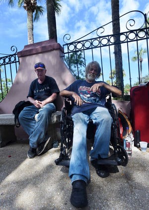 James William Gray, left, who has been homeless for about 10 years, and Lester Ray Strickland, who has been homeless for about a year, sit together on St. George Street as Saturday afternoon crowds pass by.