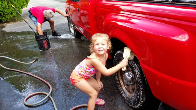 Colby helping her Papa wash his truck. Photo by Jan Stewart.