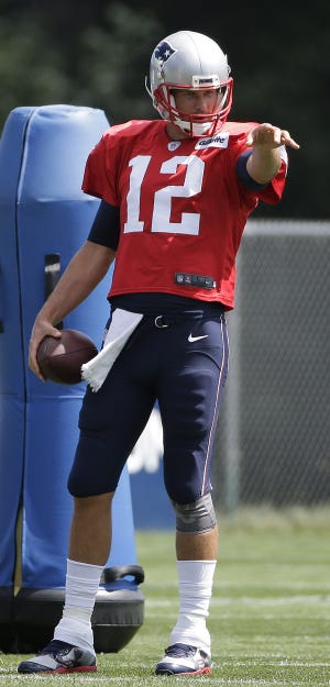 New England Patriots quarterback Tom Brady points while speaking with teammates during a practice with the Chicago Bears on Monday. THE ASSOCIATED PRESS