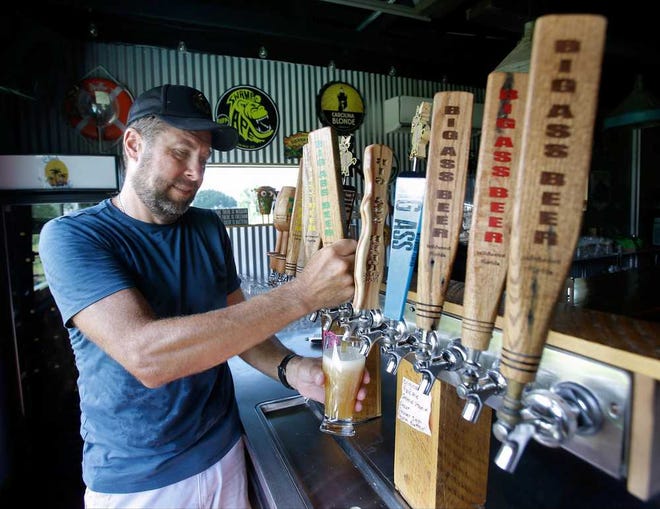 PHOTOS BY JOHN RAOUX/ AP Joe Winiarski owner of a small farm and brewery in Wildwood, Fla., pours a beer from one of the many selections that his brewery offers.