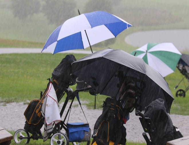 TIMES-REPORTER JIM CUMMINGS

Golf clubs sit outside of the club house Monday as rain and lighting start at the East Central Ohio League Golf tournament at Oak Shadows Golf Course. The high school tournament was canceled and rescheduled Aug. 22.