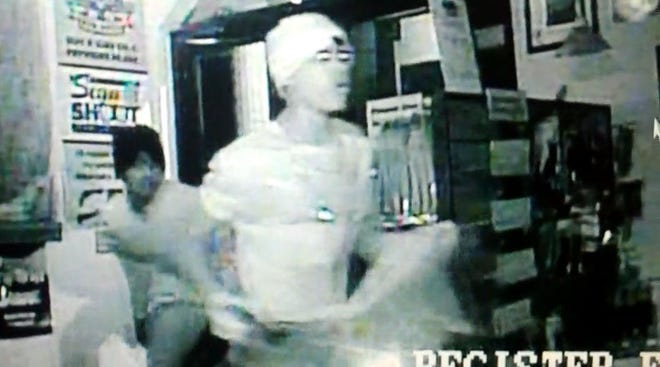 This screen grab from a surveillance video shows two of the three thieves breaking into a Mount Dora gun shop.
