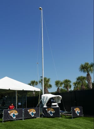 In this July 28 photo, a mobile video unit watches and records a Jacksonville Jaguars' NFL football practice while the operator works in a shaded canopy, in Jacksonville. The Jacksonville Jaguars are one of at least 10 NFL teams that have partially or completely eliminated sometimes-dangerous scissor lifts and switched to "mast cams.” The mobile units have high-definition cameras atop high-reaching poles and are controlled remotely from the ground.