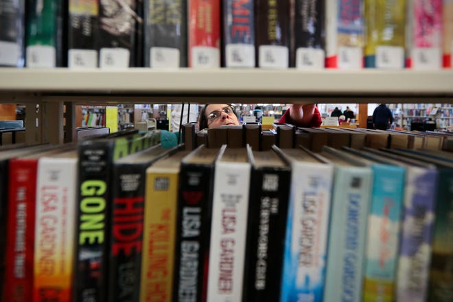 A woman browses for a good read at the Southworth Library in Dartmouth. The town's other library on Tucker Road will be torn down as part of a road realignment, so the town is looking at land on Cross Road to house a new library. PETER PEREIRA/SCMG