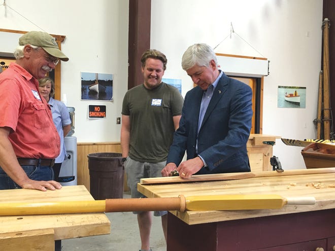 Governor Snyder shapes a canoe paddle with instructor Patrick Mahon (left) and Great Lakes Boat Building School graduate Sam Hoffrichter (center).