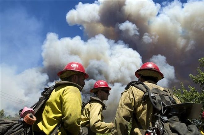 U.S. Forest Service firefighters stage before getting their assignment to cover a wildfire falls near the Cajon Pass in California, Tuesday, Aug. 16, 2016. The fire forced the shutdown of a section of Interstate 15, the main highway between Los Angeles and Las Vegas, leaving commuters stranded for hours. (James Quigg/The Daily Press via AP)