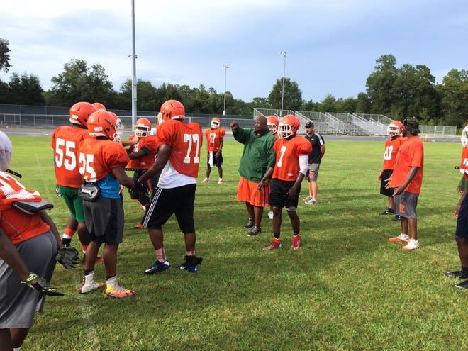 Cedderick Daniels, center, coach of the Eastside football team, points out the proper technique to use to a player during practice. Cleveland Tinker/Special to the Guardian