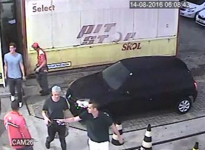 In this Sunday, Aug. 14 frame from surveillance video released by Brazil Police, U.S. swimmer Ryan Lochte, second from right, and teammates appear at a gas station during the 2016 Summer Olympics in Rio de Janeiro, Brazil. A top Brazil police official said the swimmers damaged property at the gas station. (Brazil Police via AP)