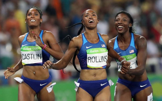 Gold medal winner Brianna Rollins, center, silver medal winner, Nia Ali, right, and bronze medal winner Kristi Castlin, all from the United States, pose with their country's flag after the 100-meter hurdles final during the athletics competitions of the 2016 Summer Olympics at the Olympic stadium in Rio de Janeiro, Brazil, Wednesday, Aug. 17, 2016.