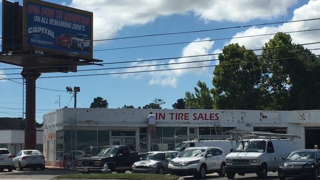 Paint crews worked Monday afternoon to replace the Jeff Fountain Tire Sales sign. Fountain sold his business to Capital Ford earlier this month. Adam Wagner/StarNews