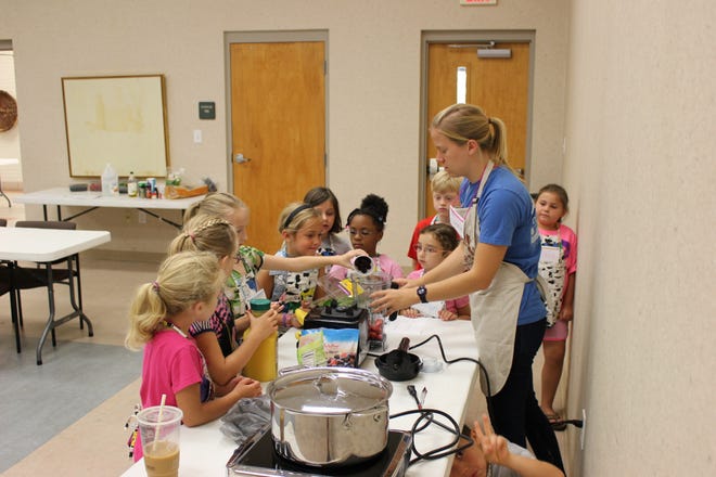Participants in a 4-H Super Summer cooking program for youth make smoothies. Linda Minges photo.