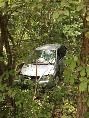 The mini-van came to rest 15 feet off the road in a tree line after taking down several small trees. COREY MURRAY PHOTO