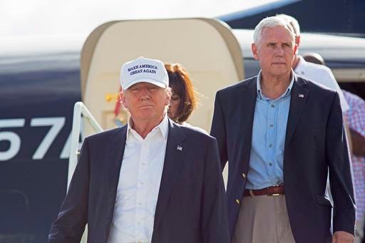 Republican presidential candidate Donald Trump, followed by his running mate, Indiana Gov. Mike Pence, emerges from his plane as he arrives to tour the flood damaged city of Baton Rouge, La., Friday, Aug. 19, 2016. (AP Photo/Max Becherer)