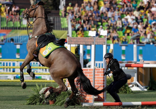 Haydy Morsy of Egypt reacts after falling from the horse as she competes at the equestrian section of the women's modern pentathlon at the Summer Olympics in Rio de Janeiro, Brazil, Friday, Aug. 19, 2016.(AP Photo/Natacha Pisarenko)