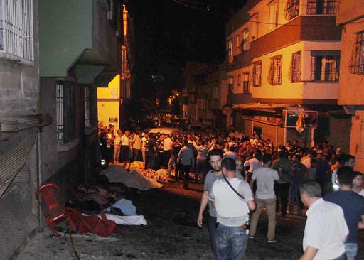 People gather after an explosion in Gaziantep, southeastern Turkey, early Sunday, Aug. 21, 2016. Gaziantep Province Gov. Ali Yerlikaya said the deadly blast, during a wedding near the border with Syria, was a terror attack. (Eyyup Burun/DHA via AP)