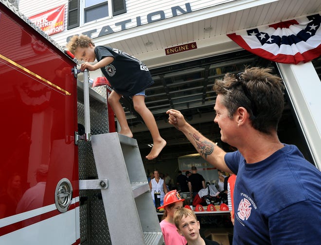York firefighter Matt Gunn stands by to help Mary Enkosky, 5, of York down from the fire truck during the open house to celebrate the York Village Fire Department's 100th anniversary on Saturday.

Photo by Ioanna Raptis/Seacoastonline