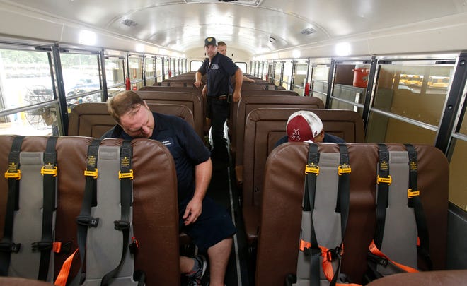 James O'Neal, left, and Will Noland, right, work with Jarrod Washington, back center and Joey DuBose as they prepare busses for the beginning of school Wednesday, August 10, 2016. The crew is installing safety seats with five point harnesses for preschoolers who will travel on the busses this year. The school system is transporting 220 preschoolers this year with is an increase of 100 over last year. Staff Photo/Gary Cosby Jr.