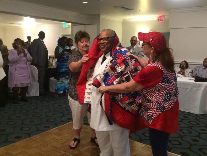 Quilts of Valor members honor WWII veteran Eddie Mitchell with a quilt during his 90th birthday celebration on Saturday night.

Monica Solano, Press Dispatch