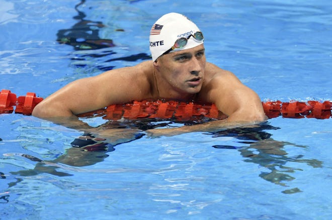 In this Aug. 9 photo, United States' Ryan Lochte checks his time after a men' 4x200-meter freestyle relay heat during the swimming competitions at the 2016 Summer Olympics in Rio de Janeiro, Brazil. The father of the American swimmer said Wednesday his son arrived back in the United States before a Brazilian judge ordered that Lochte stay in Brazil as authorities investigate a robbery claim involving the athlete during the Olympics. (AP Photo/Martin Meissner)
