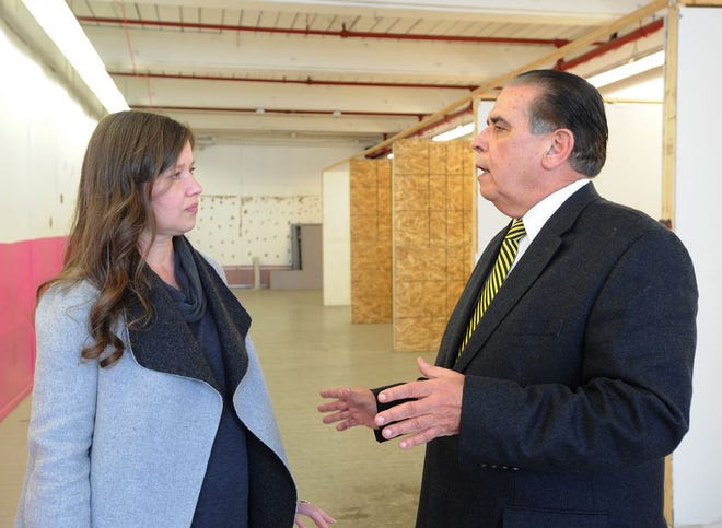 Kathryn Hilderbrand talks with state Rep. Alan Silvia in the space where she expanded her clothing manufacturing business in Fall River during a meeting in February.