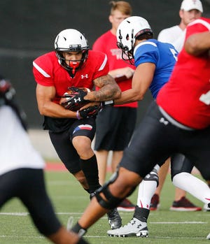 Running back Justin Stockton (4) takes a handoff from quarterback Patrick Mahomes (5) during practice Aug. 10.