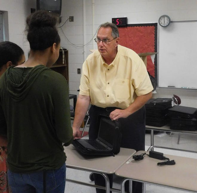 John Fux, information management coordinator for Hoke County Schools, shows a Chromebook computer to a Hoke County High School student. This school year, every student in the Hoke County school system will have access to a computer. The school system is adopting a one-to-one computer to student ratio this school year for all grades except pre-kindergarten, which will have one computer for every two students.