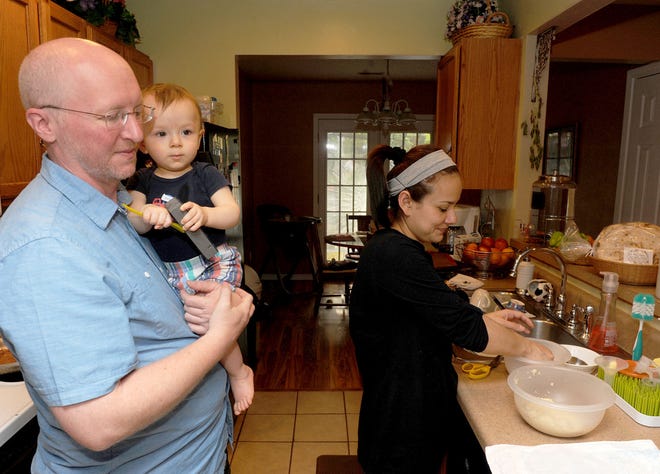 Dania Wall makes tortillas as her husband, Tim, and their son, Liam Arturo, 1, watch.