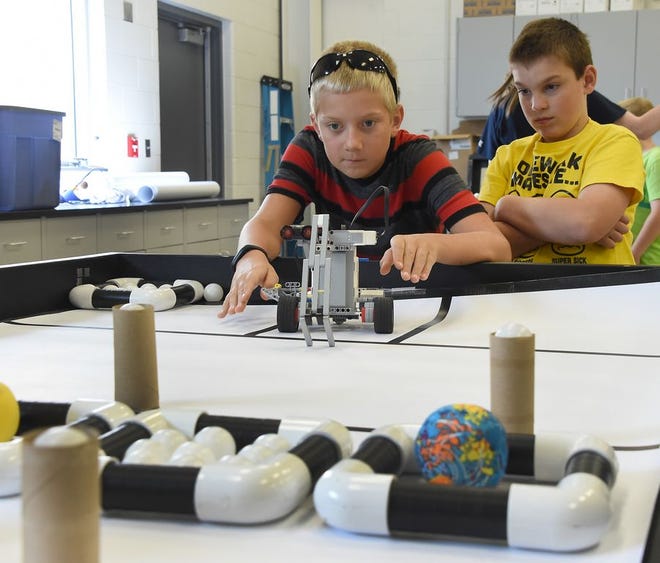 Monroe News photo by TOM HAWLEY 
Ryan Lindemann, 9, of Milan lines up his team's robot with Isaac Burkey, 9, of Monroe to practice for the bot ball competition in the advance Lego robotics camp at the Monroe County Community College Thursday.