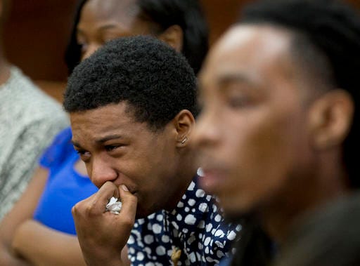 Marquez Tolbert cries Tuesday, Aug. 23, 2016, as he listens in Atlanta to testimony in the trial of Martin Blackwell, who is accused of pouring boiling water on him and a friend Anthony Gooden, right, as they slept. (AP Photo/John Bazemore)