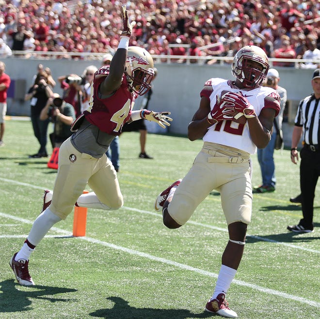 Florida State wide receiver Auden Tate, right, catches a touchdown pass in front of defensive back Xavier Hurge during the Seminoles' spring scrimmage at Camping World Stadium in Orlando on April 9.