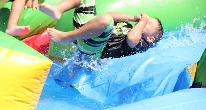 Cameron Fonseca holds his nose as he is about to reach the bottom of the water slide at the Fairhaven Recreation Center.