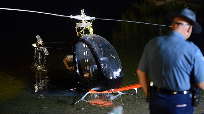 Shortly before 10 p.m. Wednesday, an ultralight helicopter is pulled out by winch from Ashland Reservoir. The pilot, David Diana of Hopkinton, crashed at 4:30 p.m. and swam to safety.  Daily News and Wicked Local Staff Photo/Ken McGagh