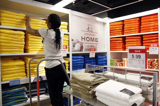 A sales clerk arranges towels that are part of a "Buy One Get One for a Penny" sale at a J.C. Penney store in New York. J.C. Penney, Nordstrom, Macy's and Kohl's are reinventing themselves amid stiffer competition from online and discount stores like T.J. Maxx. The Associated Press