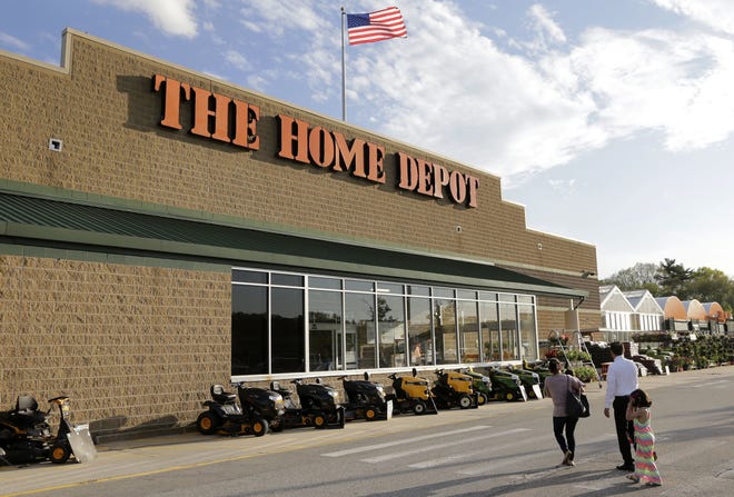 Potential customers approach an entrance to a Home Depot in Bellingham, Massachusetts. Home Depot's profits are edging out Lowe's as the housing industry makes a recovery. The Associated Press