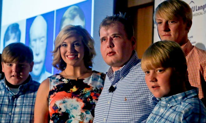 Former Mississippi firefighter Patrick Hardison, 42, center, is surrounded with his children Braden, 13, far left, Allison, 21, second from left, Cullen, 12, far right, and Dalton, 18, second from right, at a press conference marking one year after his face transplant surgery. Hardison was disfigured while trying to save people from a house fire in 2001 and received the face of a Brooklyn cyclist who died in an accident in July 2015.