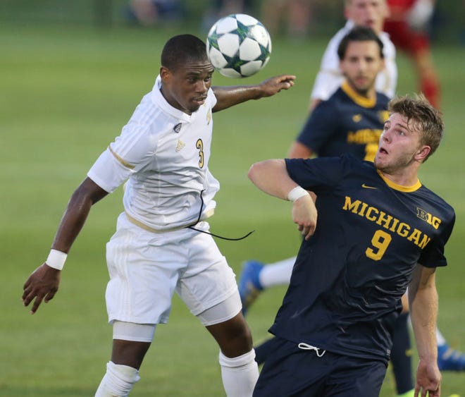 University of Akron's Nick Hinds heads a ball past Michigan's Jack Hallahan during the first half of an exhibition game at Cub Cadet Field on Aug. 19, in Akron. (Phil Masturzo/Akron Beacon Journal)
