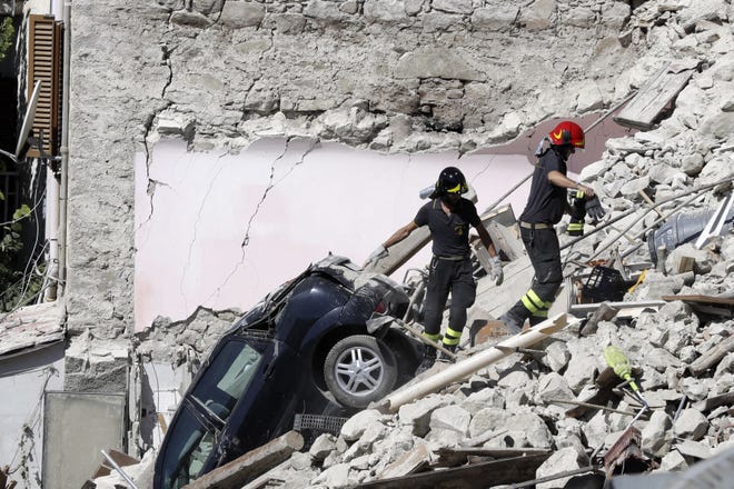Rescuers make their way through destroyed houses following Wednesday's earthquake in Pescara Del Tronto, Italy, Thursday, Aug. 25, 2016. Rescue crews raced against time Thursday looking for survivors from the earthquake that leveled three towns in central Italy, but the death toll rose to 247 and Italy once again anguished over trying to secure its medieval communities built on seismic lands. (AP Photo/Gregorio Borgia)