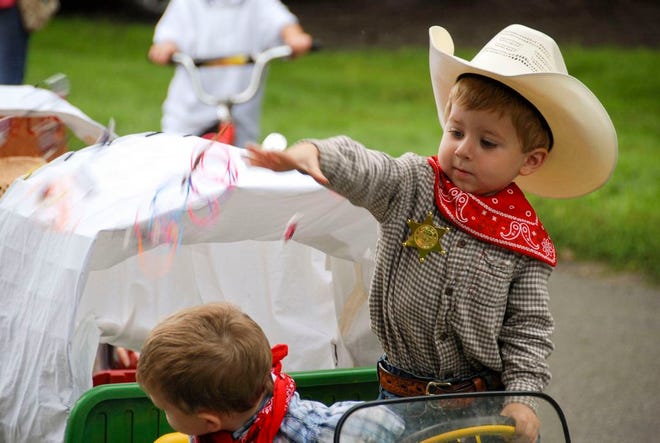 A young cowboy throws candy during the 2014 Dallas Center Fall Festival Parade. The Parade this year will take place on Saturday.