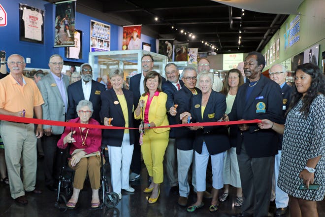 Polk County Commissioner Melody Bell, center, is about to cut the ribbon with hall of fame members at the grand opening o of the Polk County Sports Hall of Fame on Thursday.