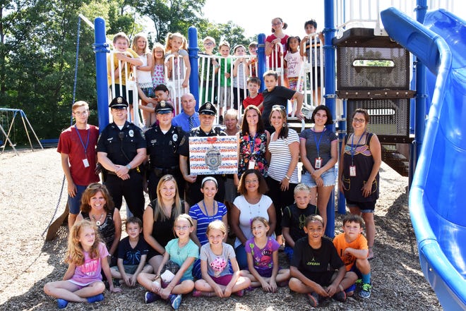 Members of the Exeter Police Department were invited to Lincoln Street School on Friday, Aug. 19, where Great Bay Kids Company staff, along with youngsters in their care, offered thanks for all the work police do in keeping them safe. As a sign of their appreciation, Emily Scarito, program director for school age programs, presented Detective Bruce Page with an original artwork on canvas depicting an Exeter police shield. The canvas is the work of Shelby Bernard, a teaching assist, and students. Also shown representing the Exeter Police Department are patrol officers Michael O'Connor and Devin West, along with Detective Patrick Mulholland. Photo by Buzz Dietterle/seacoastonline