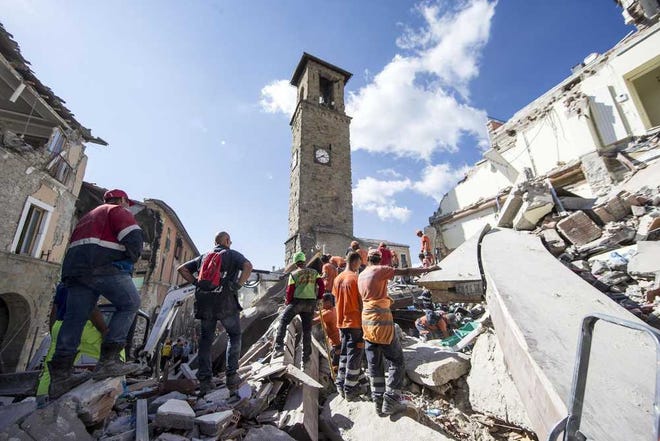 Rescuers search through debris following an earthquake in Amatrice, central Italy, Wednesday. The magnitude 6 quake struck at 3:36 a.m. and was felt across a broad swath of central Italy.