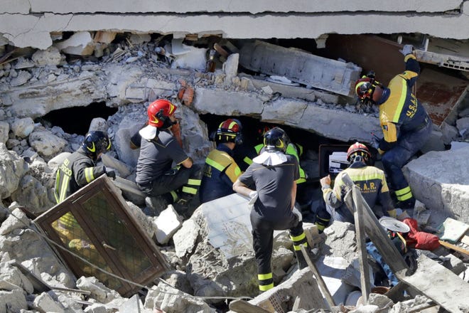 Rescuers search for victims beneath destroyed houses following Wednesday's earthquake in Pescara Del Tronto, Italy, Thursday, Aug. 25, 2016.