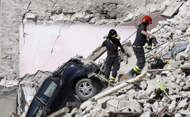 Rescuers make their way through destroyed houses following Wednesday's earthquake in Pescara Del Tronto, Italy, Thursday. (AP Photo/Gregorio Borgia)