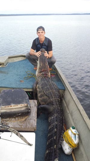 Charlie Owens shows off the 500-pound, 10-foot alligator he harvested in Lake Seminole.