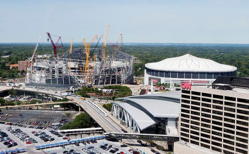 FILE - In this May 16, 2016, file photo, Mercedes-Benz Stadium, the future home of the Atlanta Falcons football team stands under construction, at left, next to the team's current stadium, the Georgia Dome, in Atlanta. The 2019 Super Bowl is scheduled to be played at the new stadium. (AP Photo/David Goldman, File)