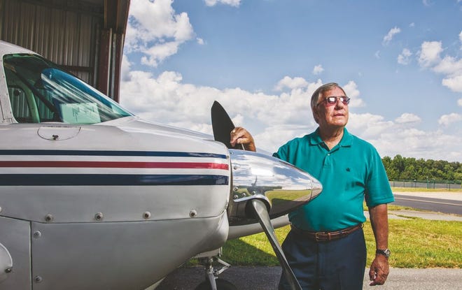 Joe Spencer poses with his plane parked in a hangar at Asheboro Municipal Airport on Aug. 23, 2016.
