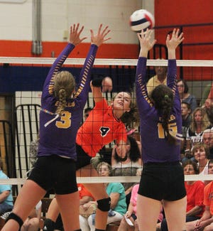 Pontiac’s Madison Wright (4) delivers an attack past two Rantoul defenders in Thursday’s home-opening volleyball match at PTHS. The Indians lost a heartbreaking, three-set decision.